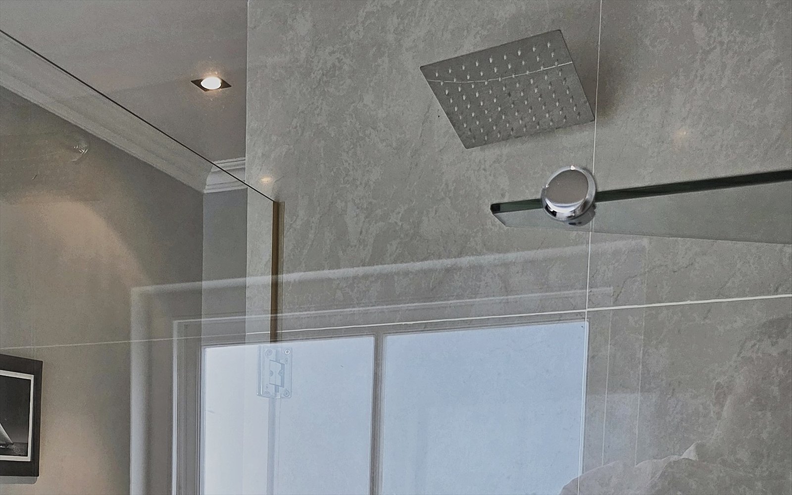 Inloopdouche met regendouche achter een glazen wand