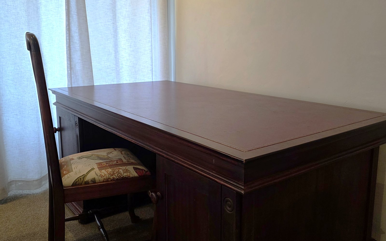 Mahoniehouten bureau met stoel bij het raam in The Library