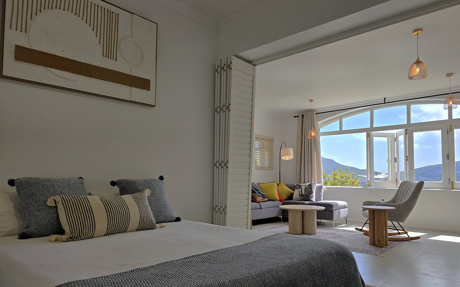 Slaapkamer van The Lodge met doorkijk naar de woonkamer en het uitzicht over Hout Bay