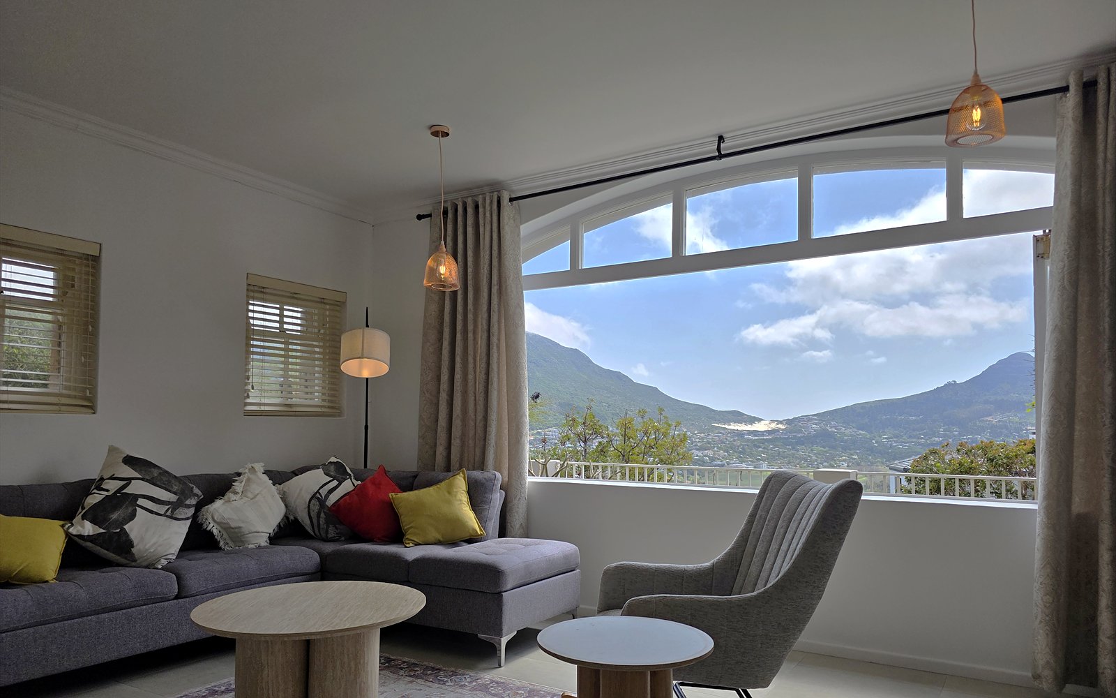 Zitgedeelte van The Lodge met hoekbank, fauteuil en boograam met bergzicht