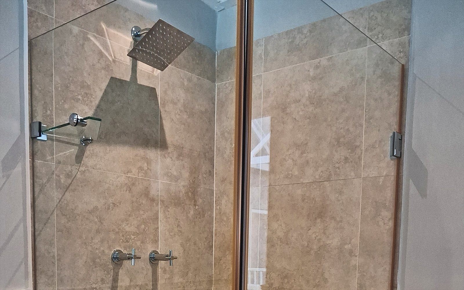 Inloopdouche met regendouchekop achter glas in de badkamer van The Split